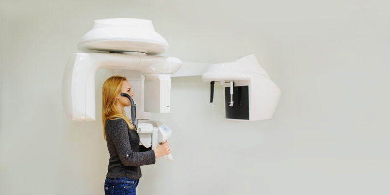 Young woman in a dental 3D x-ray digital scanner