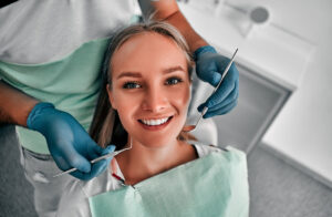 Perfect smile! Part of dentist examining his beautiful patient in dentist’s office.