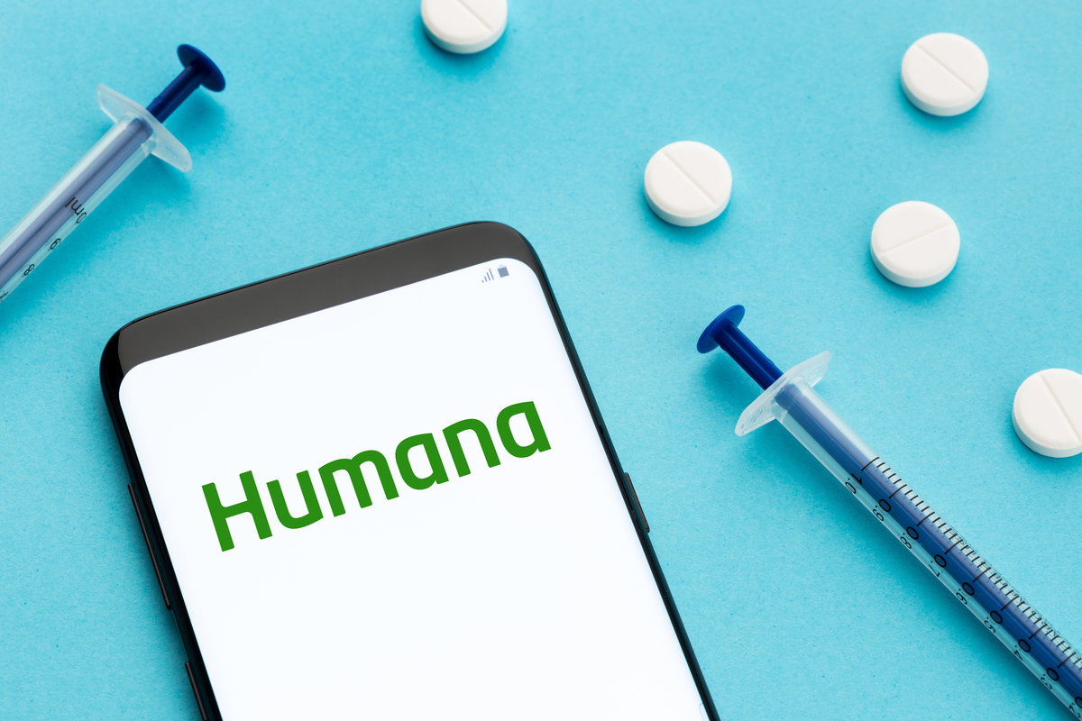 Galicia, Spain; June 8, 2021 : Humana logo on Smart phone screen pills and syringe on blue background