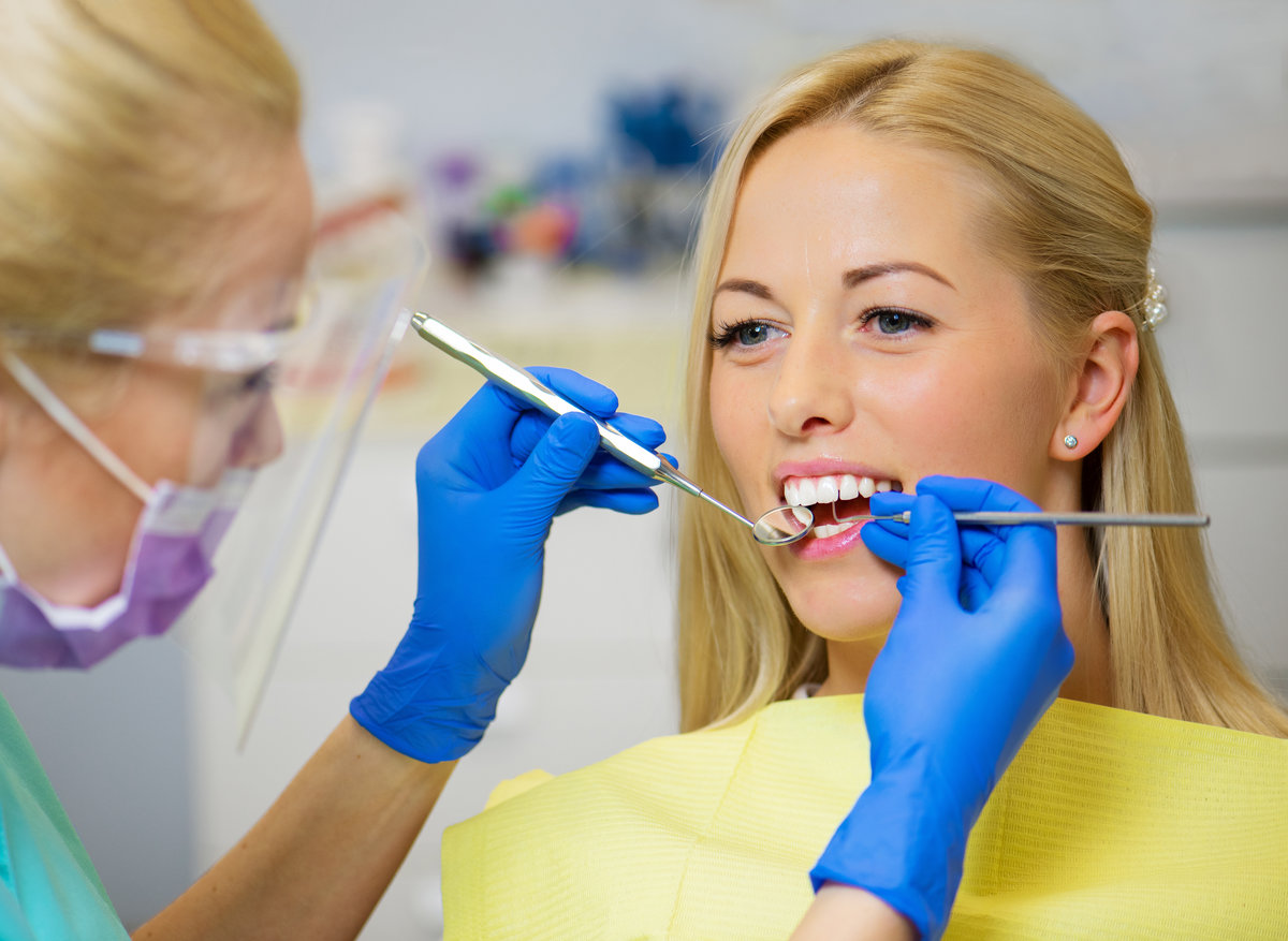 Female patient having her teeth checked by dentist