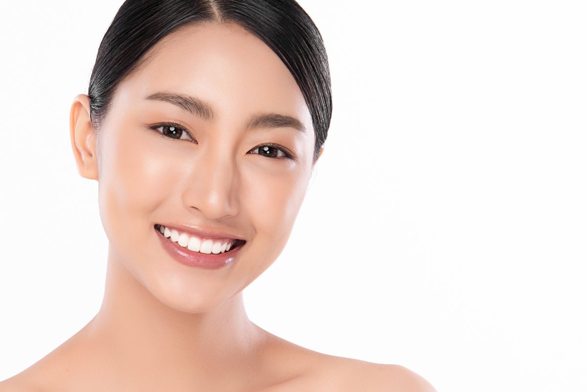 Beautiful smile young woman. White teeth on the master plan. Free space and white background,