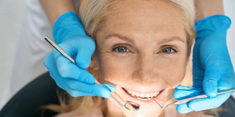 Close-up of beautiful patient is having teeth examined by dentist in clinic